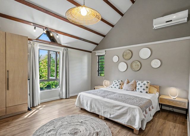 Bedroom with cathedral ceiling and garden view window