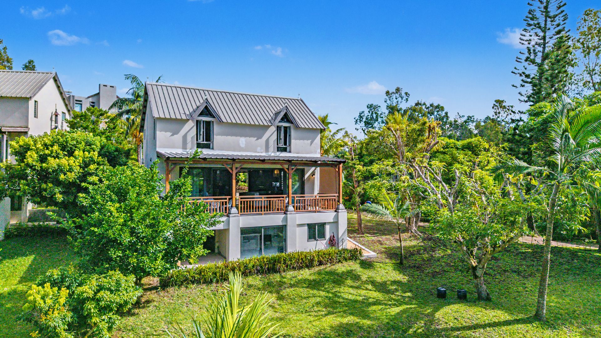 L'Albizia — a white Creole-style chalet with a wooden veranda, nestled in a lush tropical garden in Chamarel